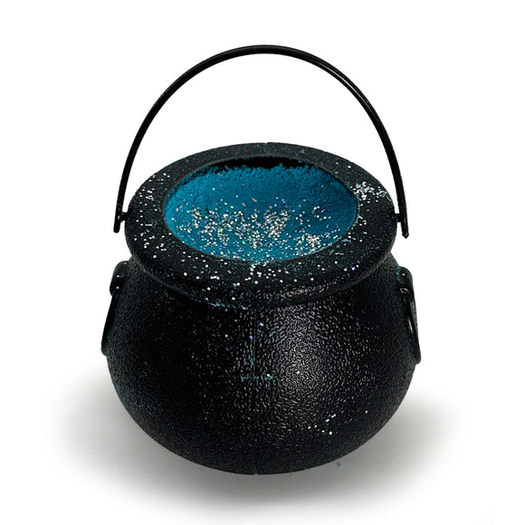 black cauldron with blue bath bom inside on white background