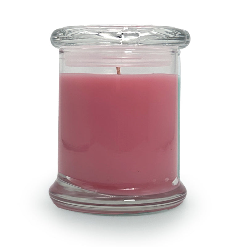 Pink candle in a clear glass jar on a white background