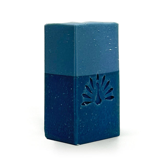 Blue rectangular soap bar with a peacock feather design on a white background