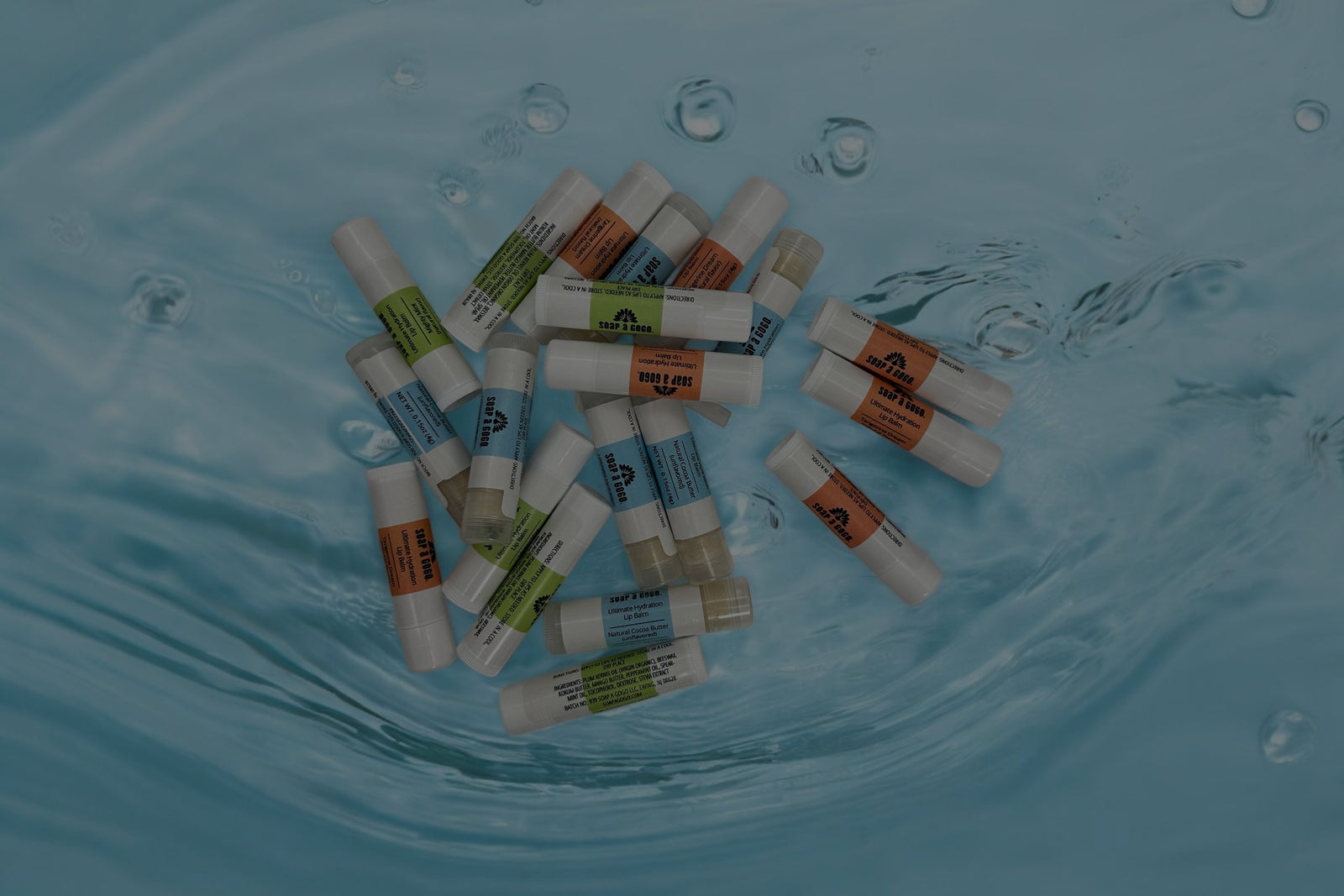 an assortment of lip balms in a pool of water