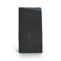 Black soap bar with a logo design on a white background