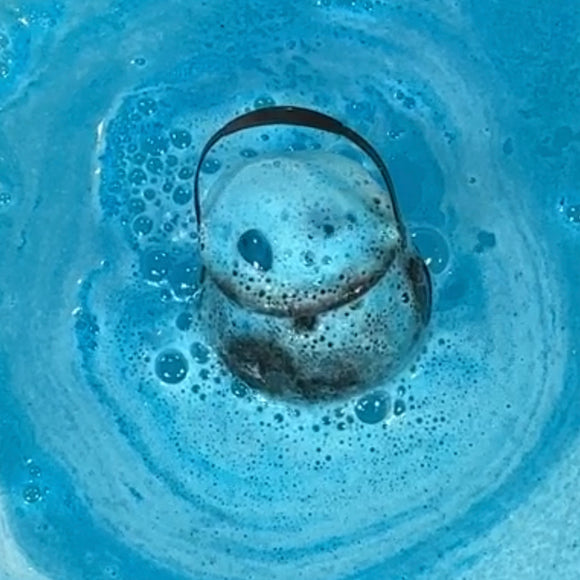 witch's brew bath bomb cauldron in the water showing blue foam and bubbles