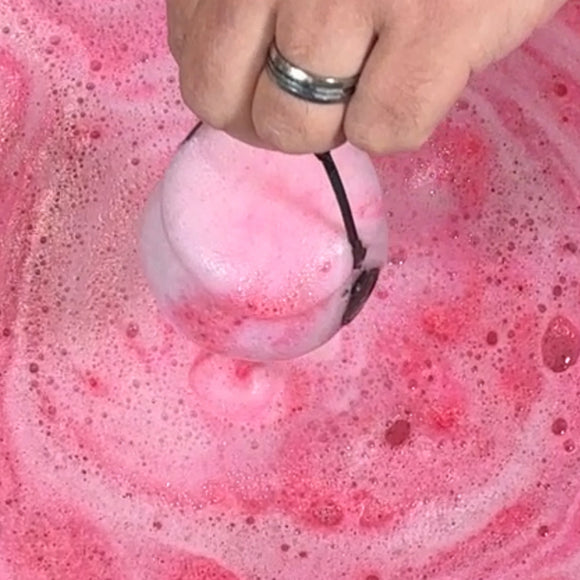 vampire bite bath bomb cauldron in the water with pink foam and bubbles