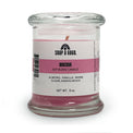 Candle in a glass jar with a label on a white background