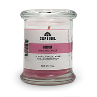Candle in a glass jar with a label on a white background