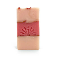 Three-layered soap bar with pink colors and gold accents on a white background