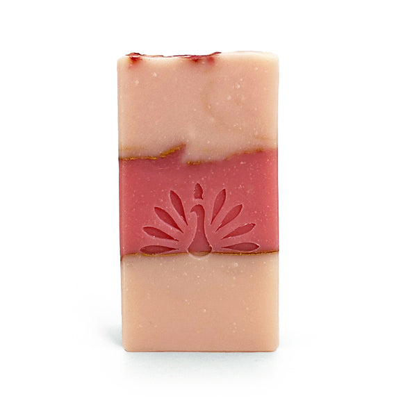Three-layered soap bar with pink colors and gold accents on a white background