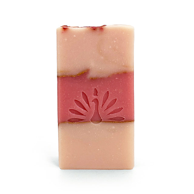 Three-layered soap bar with pink colors and gold accents on a white background