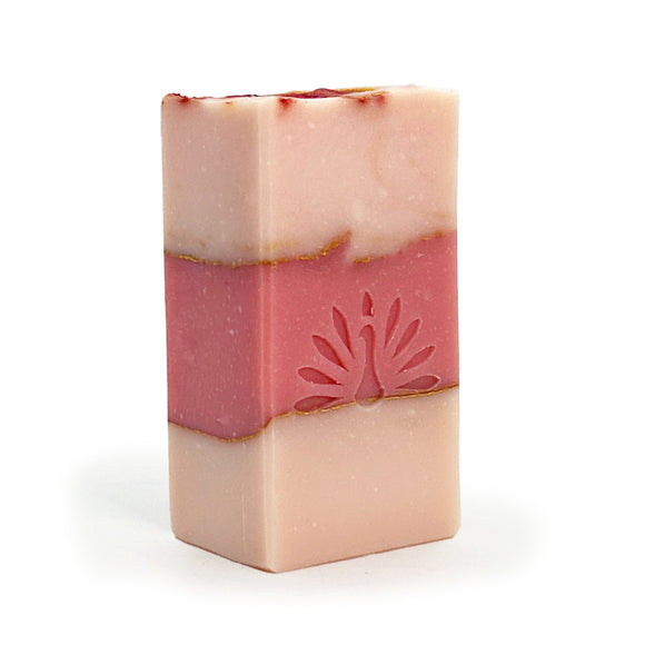 Three-layered soap bar with pink colors and gold accents on a white background