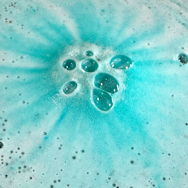 Close-up of blue bath bomb in water with bubbles