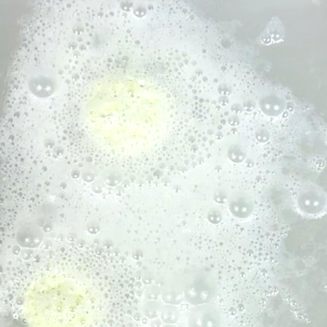 Foamy liquid with bubbles in a white container