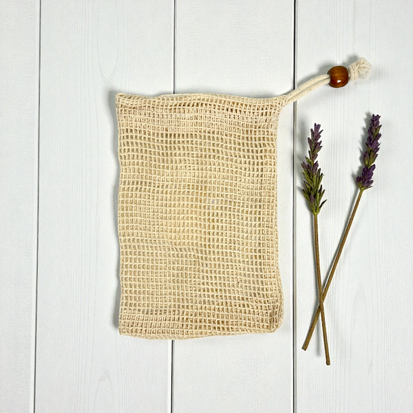 cotton soap saver pouch on a white wood background