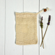 cotton soap saver pouch on a white wood background