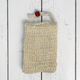 Sisal fiber soap saver pouch with draw string and wooden bead on a white wooden surface