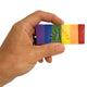 Hand holding a rainbow-colored soap with embossed logo on a white background