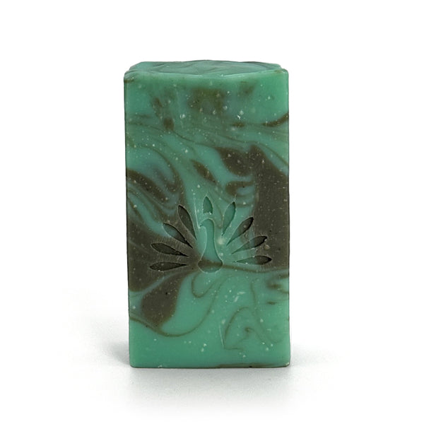 Green and gray swirled soap bar with with peacock logo on a white background