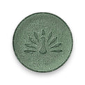 A round green shampoo bar with a peacock logo pattern on the top surface.