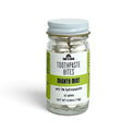 A clear glass jar of Soap A GoGo Toothpaste Bites in 'Mighty Mint' flavor, containing 42 tablets, with a white lid and a white and green label.