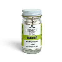 A clear glass jar of Soap A GoGo Toothpaste Bites in 'Mighty Mint' flavor, containing 42 tablets, with a white lid and a white and green label.