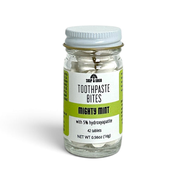 A clear glass jar of Soap A GoGo Toothpaste Bites in 'Mighty Mint' flavor, containing 42 tablets, with a white lid and a white and green label.