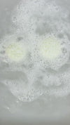 Coconut lime macaron bath bomb in a tub